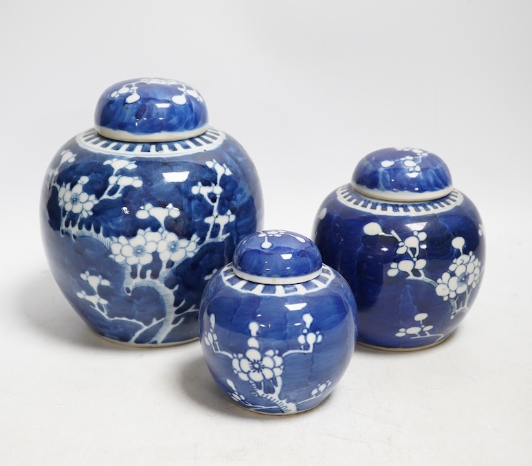 Three late 19th century Chinese blue and white prunus jars, tallest 15cm. Condition - one cover broken in two and re-glued, otherwise good